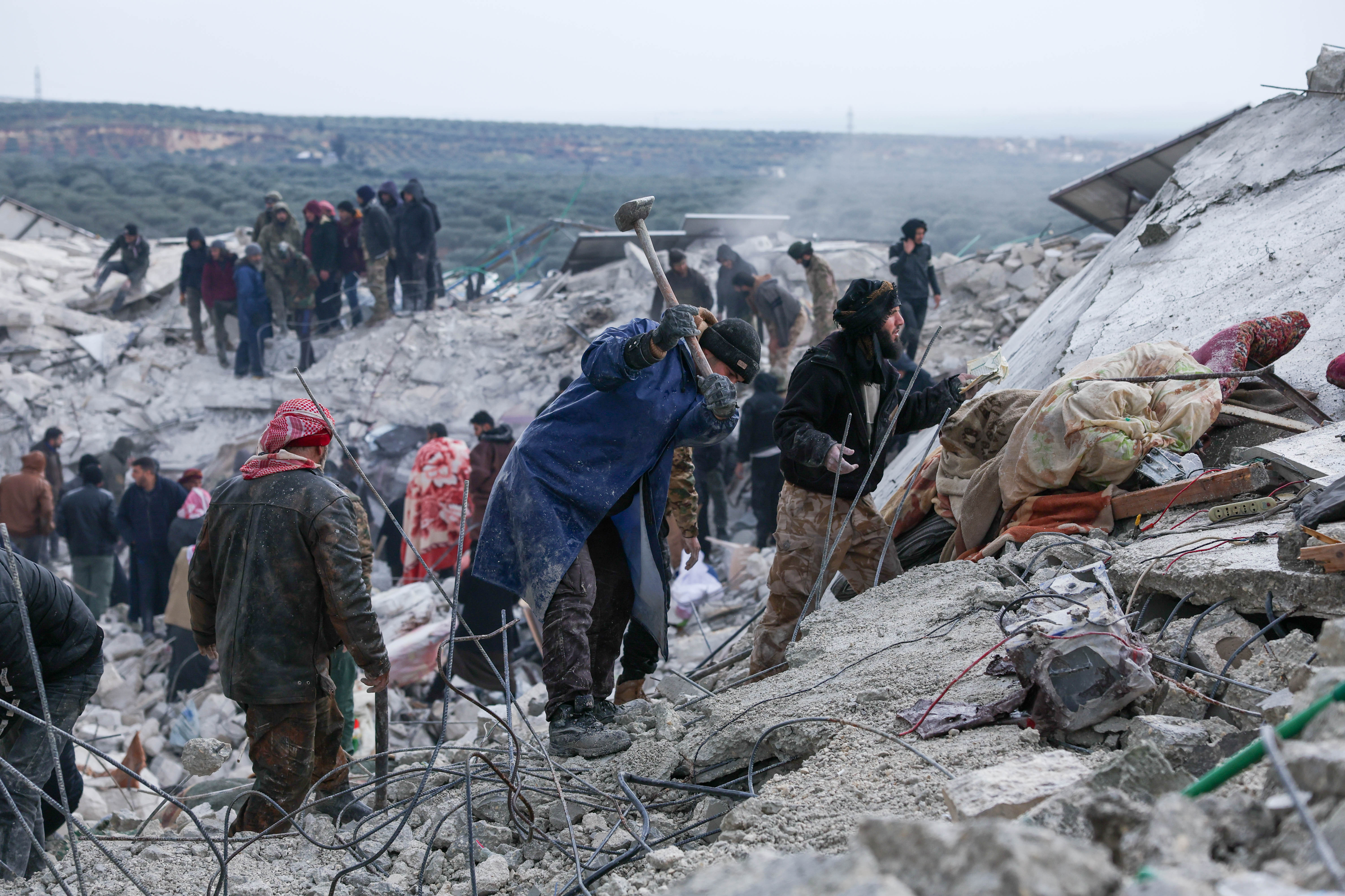 People gather amongst the rubble of destroyed buildings in Idlib province. 
