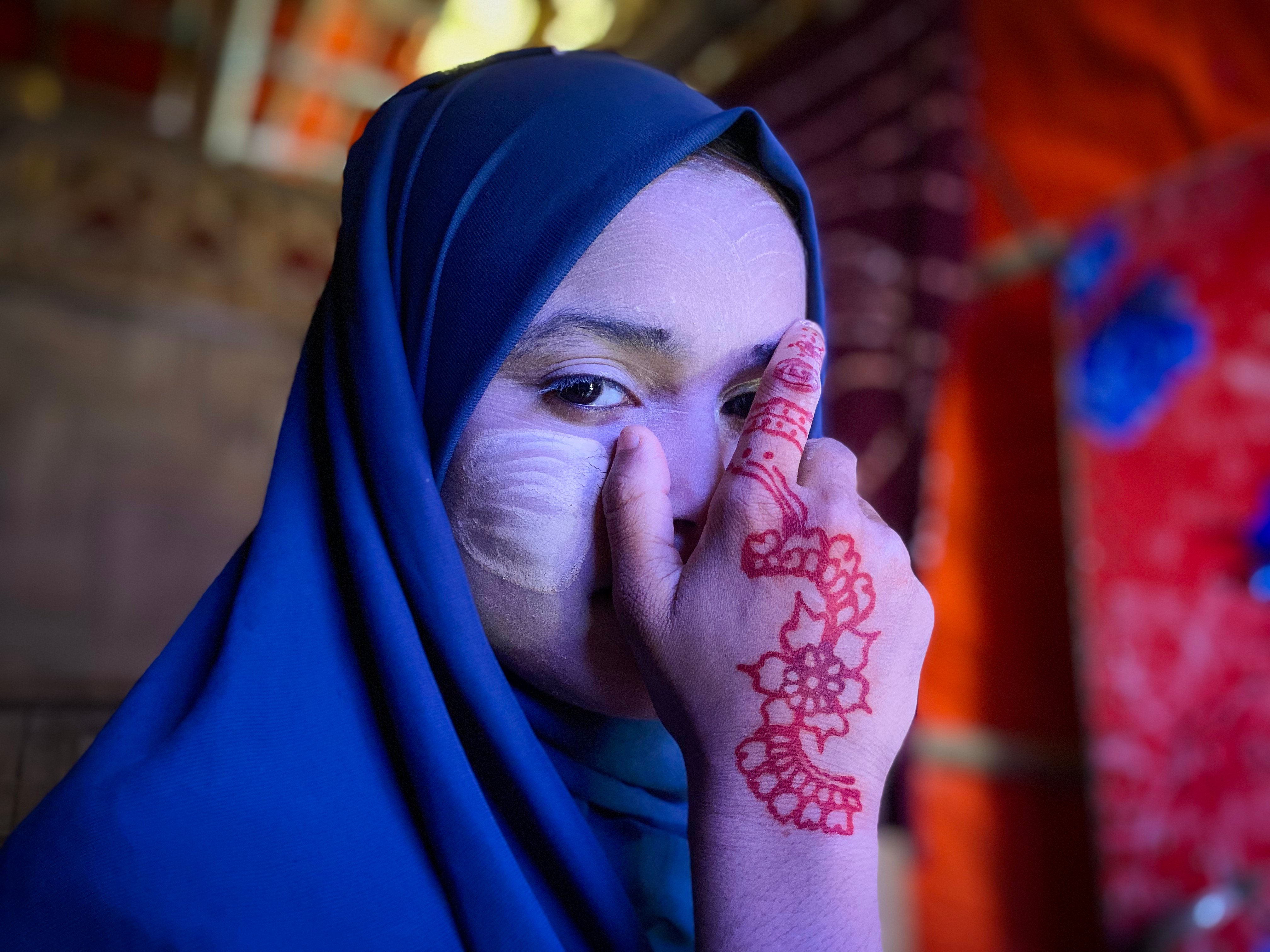 Rohingya girl poses with tanaka, a traditional cosmetic, on her face.