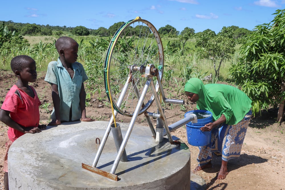 water-pump-being-used-by-mother-and-children