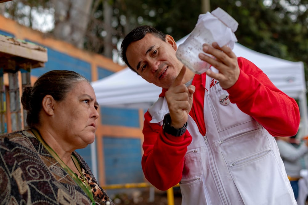 A neighbour of colonia Canaán, watches as mosquitoes that will be released into her community