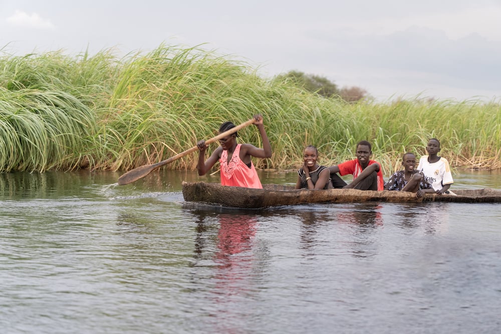 People from a village in the Sudd wetlands travel by small canoe