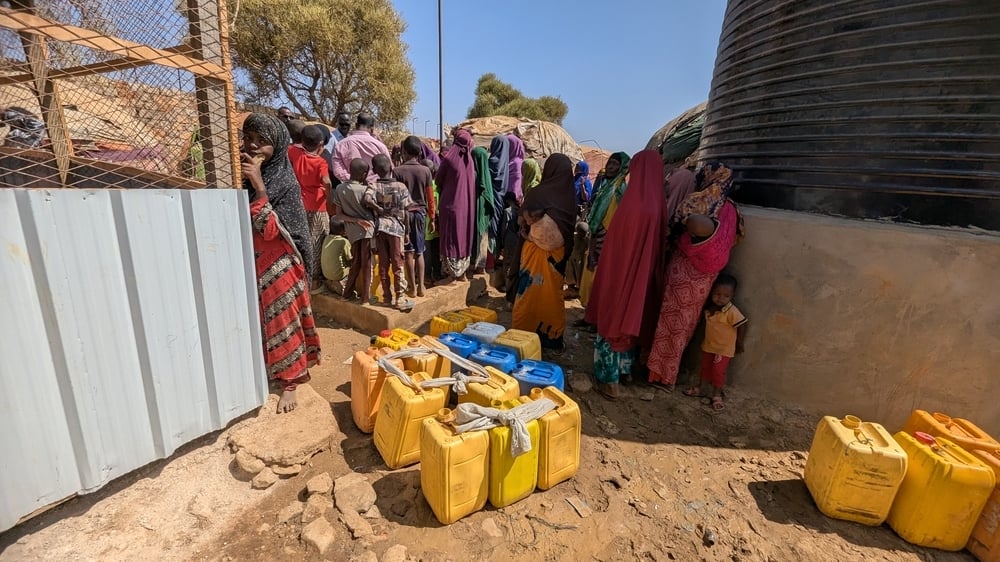 community members gather at a water distribution point