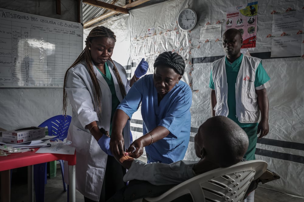 Medical staff care for a patient at the Buhimba cholera treatment centre