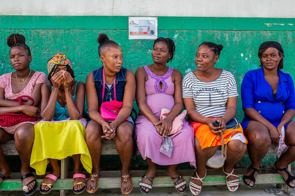 A group of women wait their turn in the courtyard inside the Maternity Isaïe Jeanty