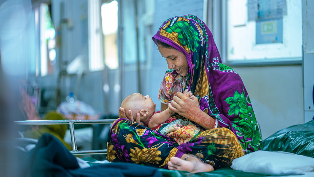 Mina Bala sits with her two-month-old daughter, Misti Foti