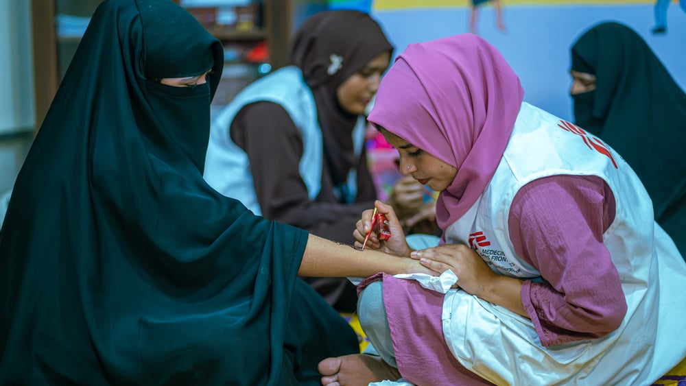 Social worker Fatema Jinnat Laboni applies henna to a patient as part of a psychosocial session