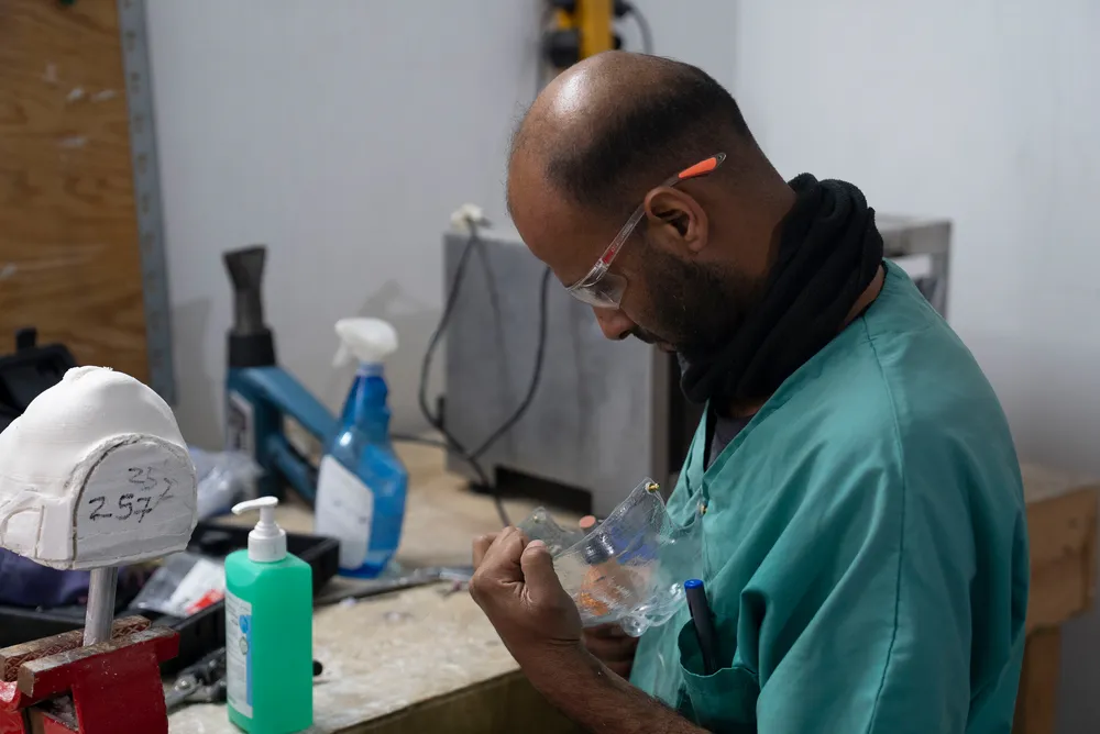 Physiotherapist smooths the edges of a custom-made 3D mask 