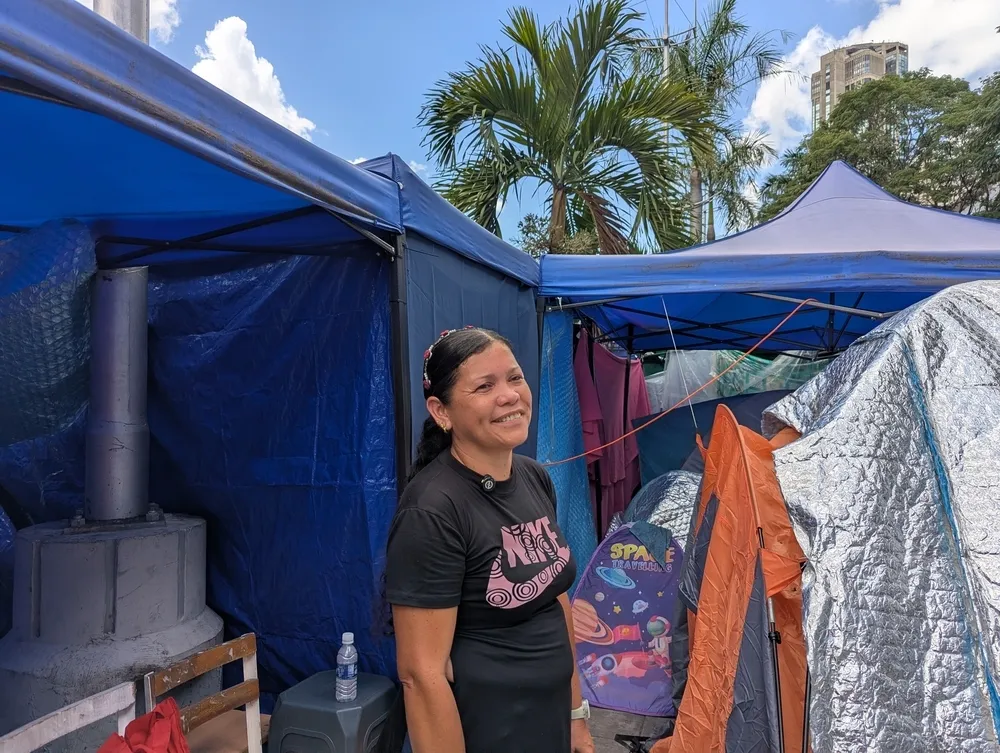Survivor Yaritza Jiménez stands outside her temporary tent