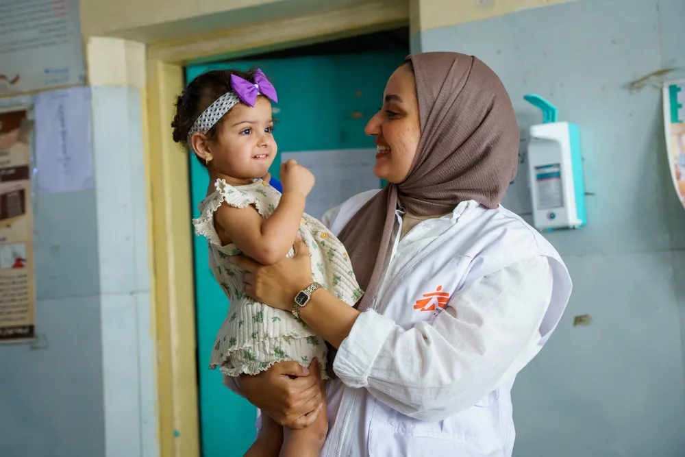 An MSF healthcare worker with a young patient in Baghdad, Iraq, 2025.