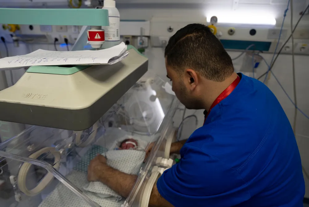 A staff member at Al-Helou Hospital in Gaza City checks on a low-weight newborn