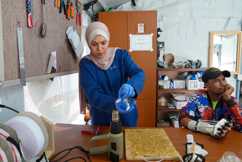 a physiotherapist heats a sheet of thermoplastic material to mould it into a custom splint