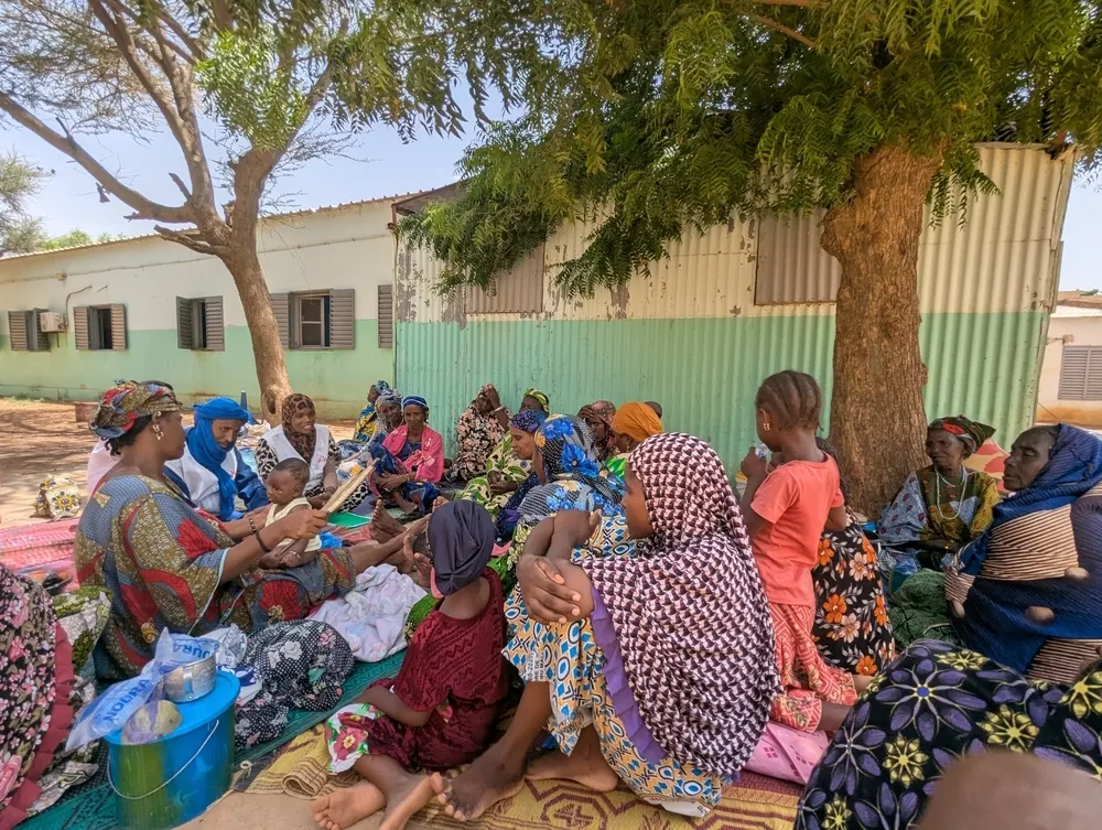 In the courtyard of Douentza Hospital, an MSF health promotion team is holding an educational talk with carers