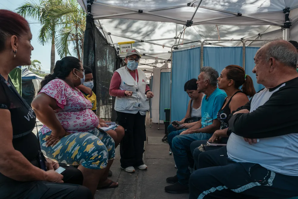 People wait in line to receive medical care inside an MSF tent 