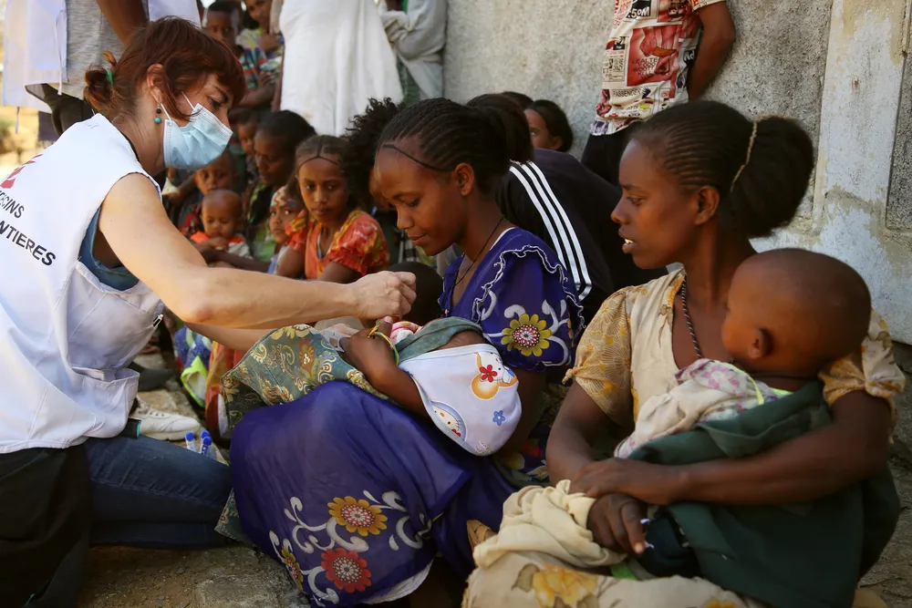 MSF nurse Naiara checks the middle-upper arm circumference of a child brought for a medical consultation by her mother to a mobile clinic in the village of Adiftaw, Tigray. © Igor Barbero/MSF