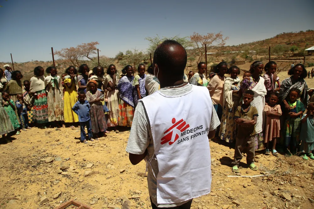 MSF translator Tedros gives instructions to women waiting with their children for a medical consultation at a mobile clinic in the village of Adiftaw, Tigray. © Igor Barbero/MSF