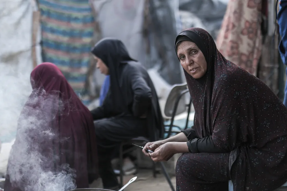 Hanan cooks over an open flame, the only way to feed her family. A glimpse into daily life marked by exhaustion and perseverance. 