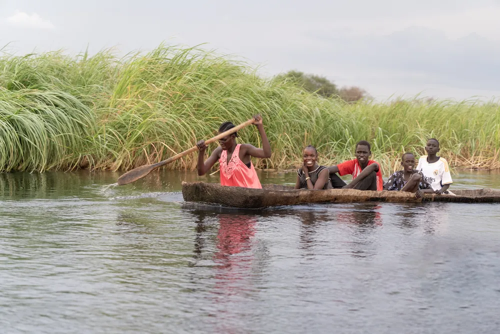 People from a village in the Sudd wetlands travel by small canoe