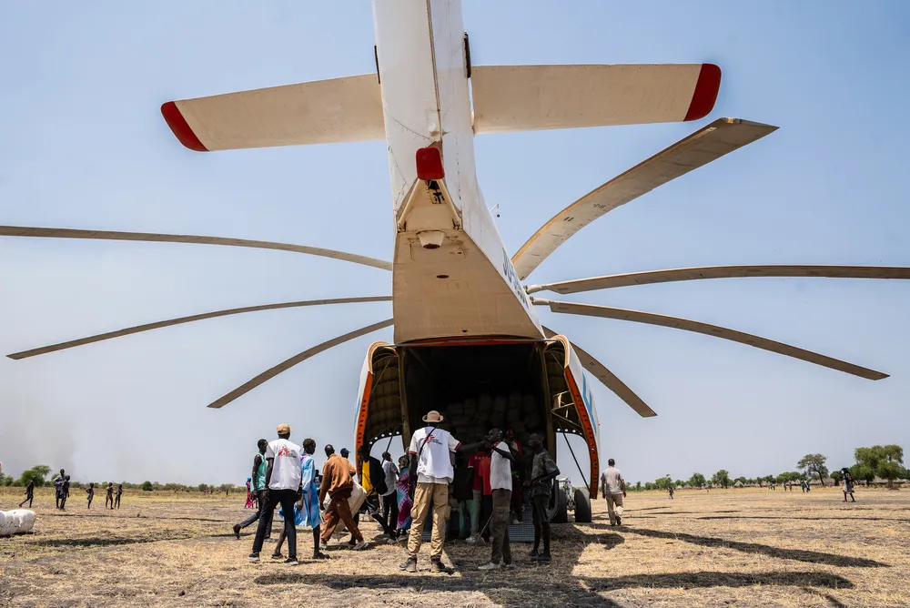 MSF staff offload non-food relief from a helicopter