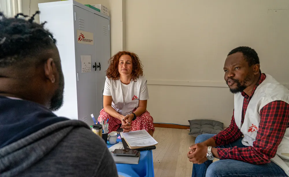 MSF psychologist and cultural mediator speak with patient during a mental health session