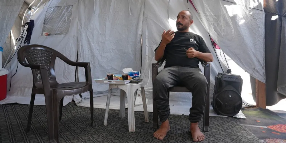 Ashraf sitting in a tent