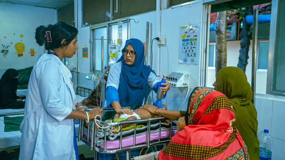 Nurses assist 10-day-old Aiyan Arfan