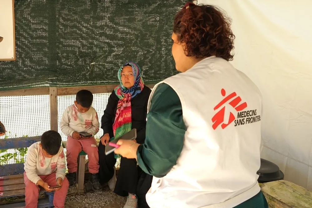MSF health promotion officer Atefeh Safari Alamuti speaks with a family from Afghanistan